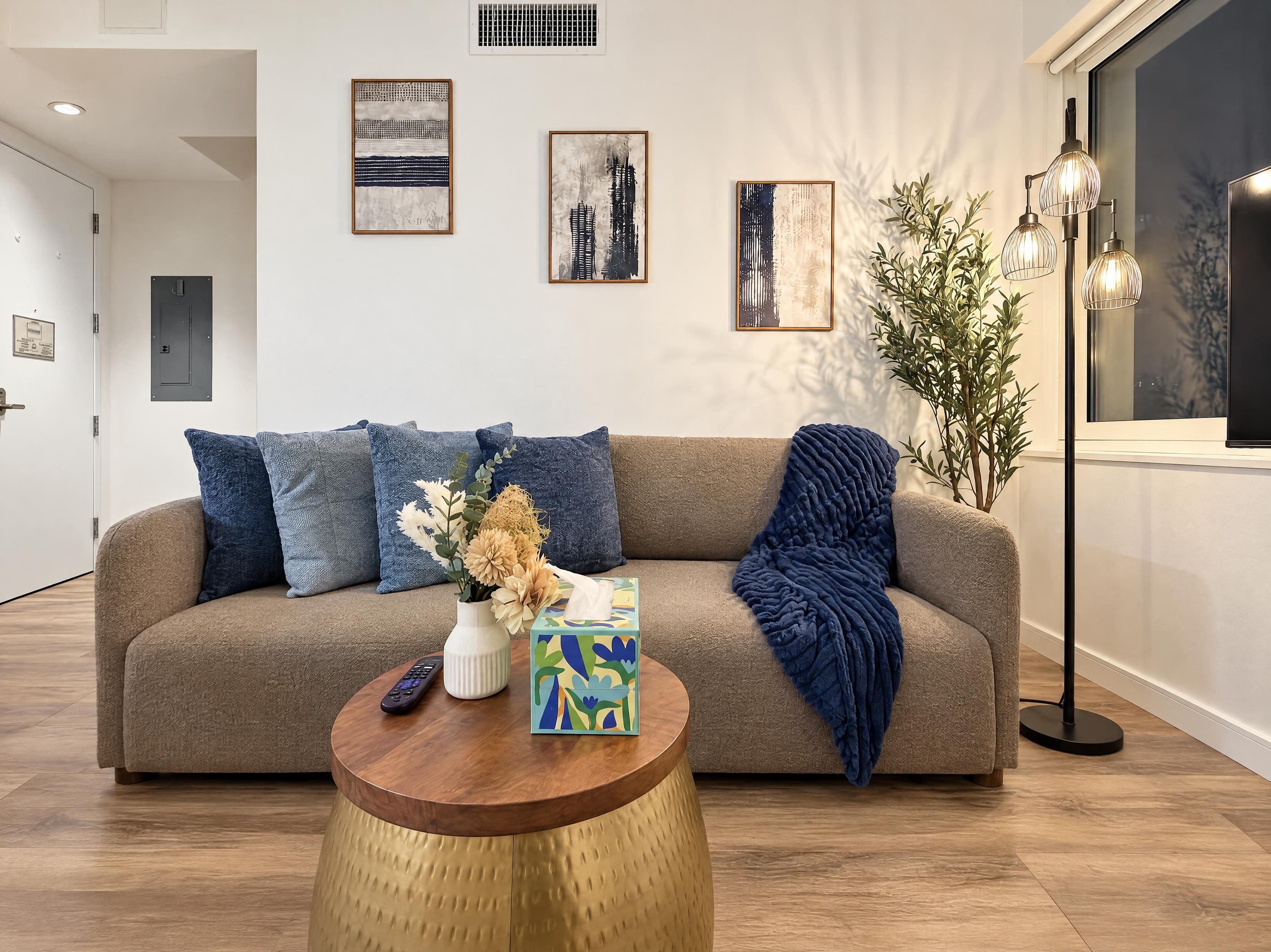 A modern living room with a sofa, a coffee table, and artwork on the wall.