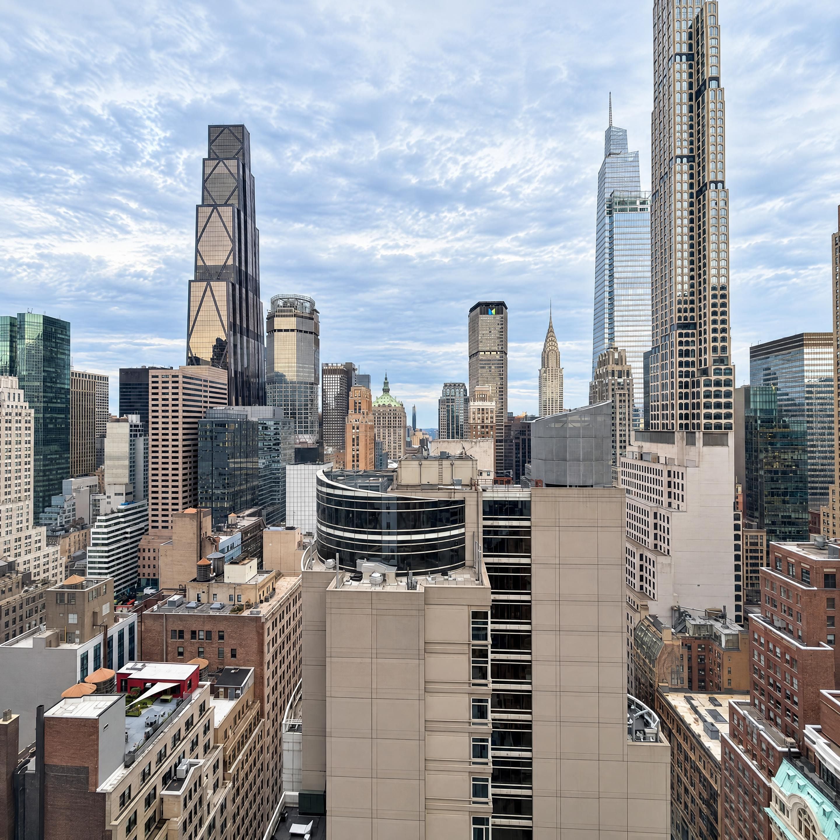 A cityscape with a variety of high-rise buildings, including a distinctive skyscraper with a unique architectural design.