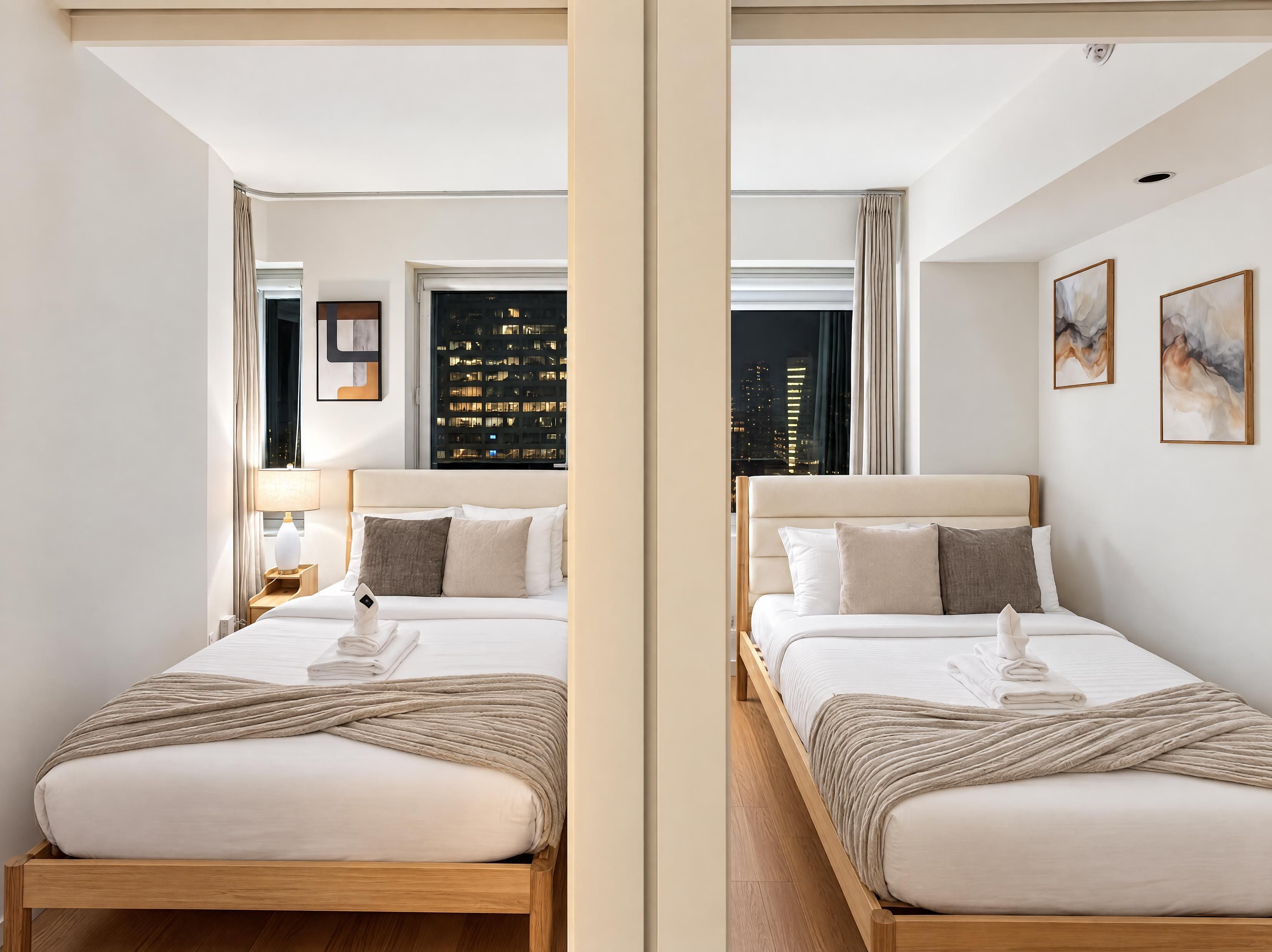 Une chambre d’hôtel avec deux lits, une vue sur la ville et un design moderne.