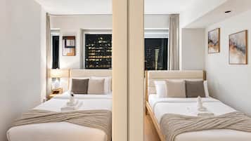 A hotel room with two beds, a city view, and a modern design.