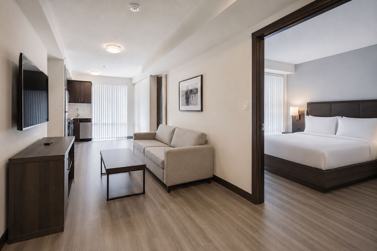Habitación de hotel con cama, sofá, escritorio y televisor.