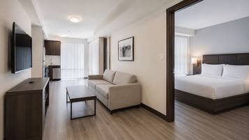 Habitación de hotel con cama, sofá, escritorio y televisor.