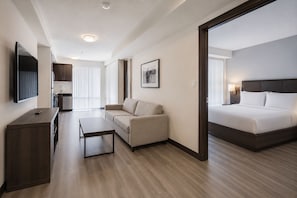 A hotel room with a bed, a sofa, a desk, and a television. - Modern Manhattan Condo Near Times Square (New York)
