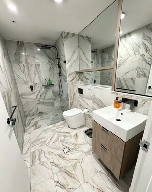 Un baño moderno con ducha, inodoro y lavamanos.
