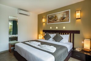 A hotel room with a bed, bedside lamps, a painting on the wall, and an air conditioning unit. - Spacious 6-bedroom hotel in amazing Bentota with AC (Bentota)