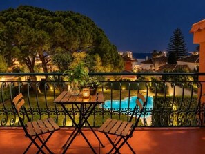 A balcony with a pool, chairs, and a table. - Renovated Two-Bedroom Apartment with Two Terraces and Sea Views (Benalmádena)