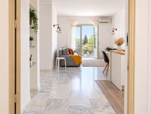 Un intérieur moderne avec un canapé, un coin repas et une vue sur l’extérieur.