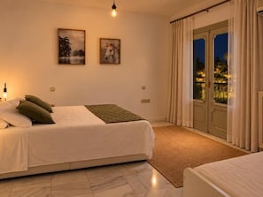 A bedroom with a bed, a nightstand, a window with curtains, and a view of the outside. - Renovated Two-Bedroom Apartment with Two Terraces and Sea Views (Benalmádena)