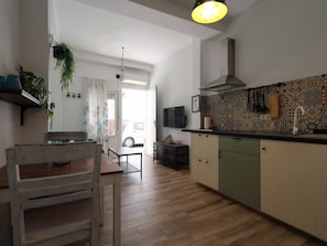 Una cocina moderna con piso de madera, un comedor con mesa y sillas de madera, y una isla de cocina.