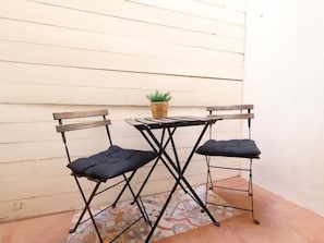 A small outdoor seating area with two foldable chairs and a table, a potted plant, and a patterned rug. - Studio with Patio in Central Arroyo de la Miel (Benalmádena)