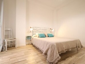 A bedroom with a bed, bedside tables, and a chair. - Studio with Patio in Central Arroyo de la Miel (Benalmádena)