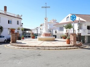 A roundabout with a central monument, surrounded by buildings and a parked car. - Studio with Private Patio in Arroyo de la Miel (Benalmádena)