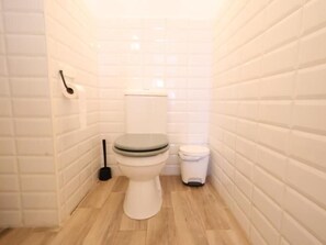 Ein kleines, kompaktes Badezimmer mit Toilette, Bidet und Mülleimer.