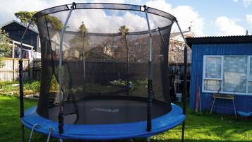 A trampoline with a safety net enclosure in a backyard.