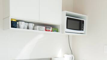 A modern kitchen with a built-in washing machine, a microwave, and a sink.