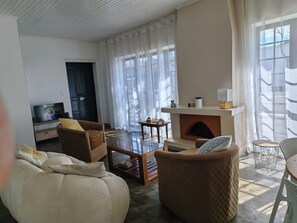 A living room with a fireplace, a television, and a sofa. - Cozy villa with a pool, 5 minutes from the airport and close to all amenities (Talatamaty)