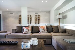 A modern living room with a sectional sofa, decorative pillows, a coffee table, and wall-mounted sculptures. - Dromana Relaxation Escape by Ready Set Stay- Positioned on a cliff & WiFi (Dromana)