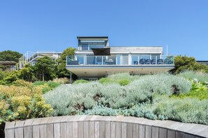 Una casa moderna con balcón que da a un jardín.