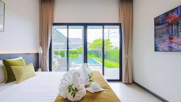 Habitación de hotel con una cama, un ventanal y vistas a una piscina y zonas verdes.