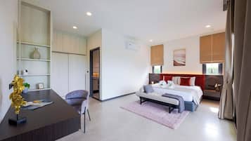 Quarto de hotel moderno com cama, escrivaninha e cadeira. Há uma janela grande com cortinas, ar condicionado na parede e um quadro na parede.