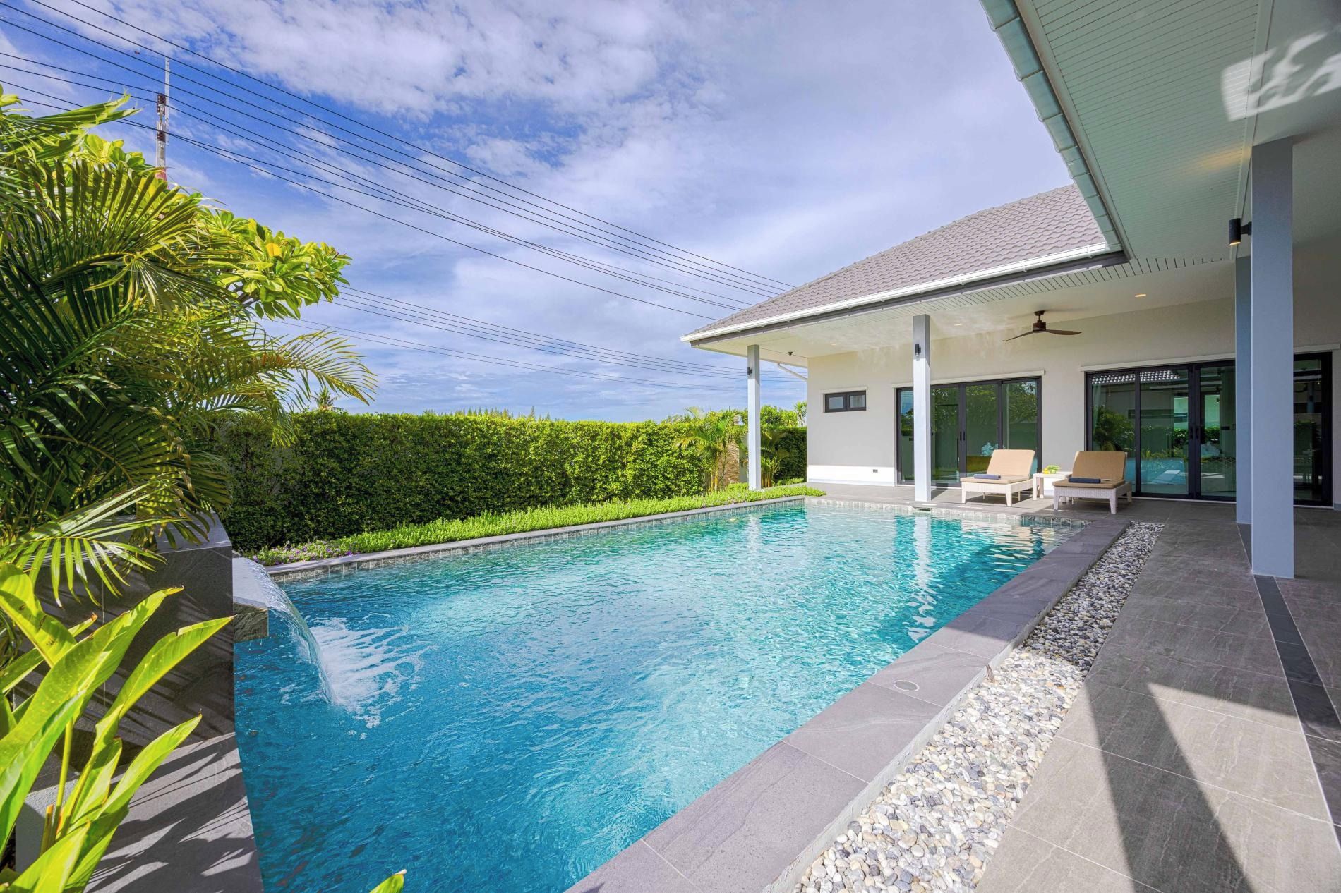 Una casa moderna con piscina, un porche cubierto y vistas al cielo.