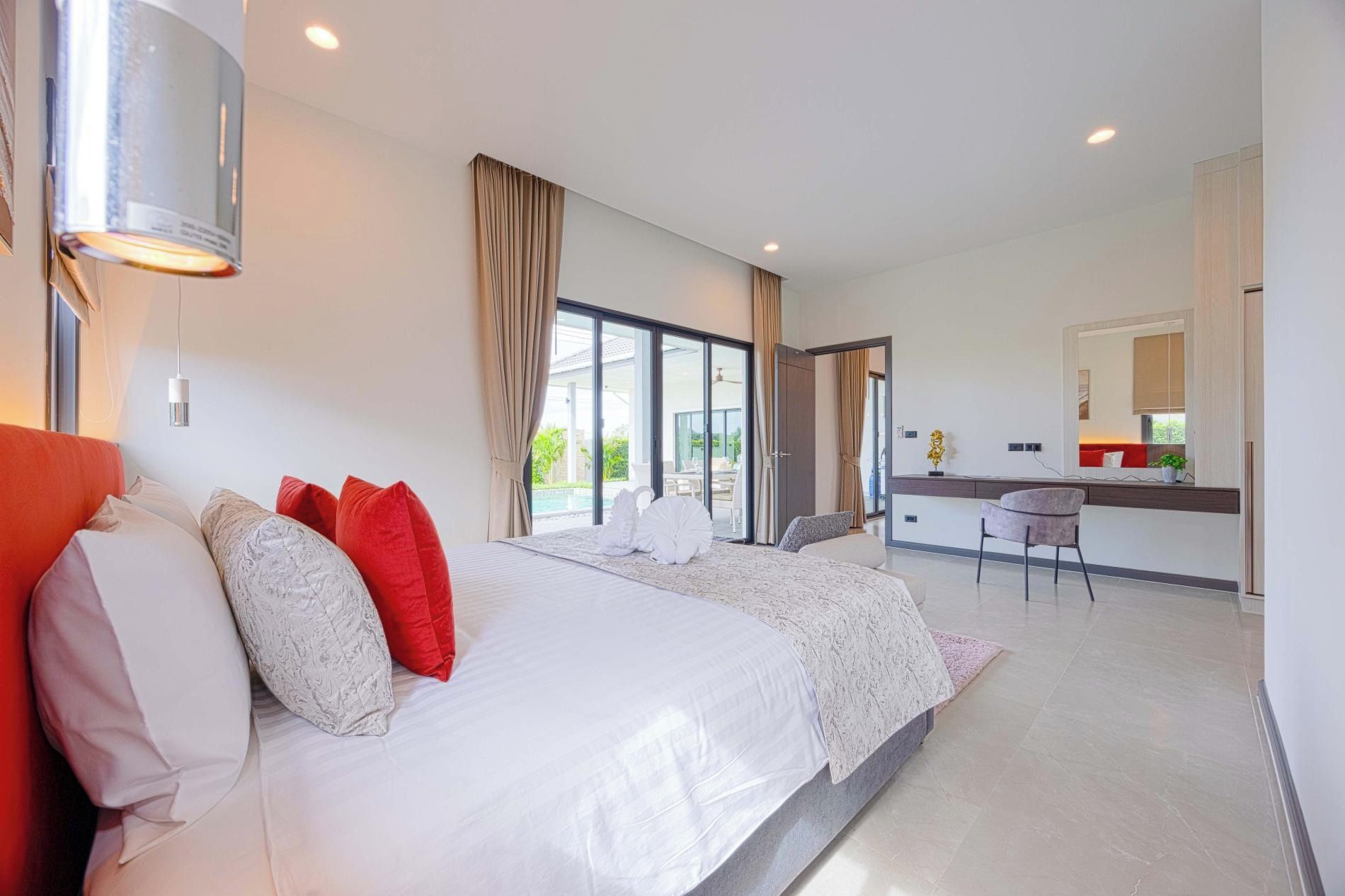 Une chambre d’hôtel moderne, dotée d’un grand lit, d’un bureau et offrant une vue sur l’extérieur.