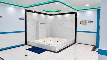 A modern bathroom with a marble vanity, a bathtub, and a shower enclosure.