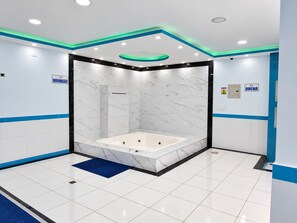 A modern bathroom with a marble vanity, a bathtub, and a shower enclosure. - Hotel Marques Amazonico (Nueva Loja)
