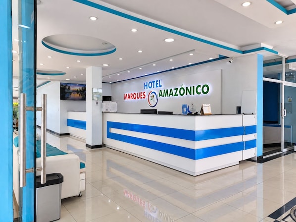A hotel reception desk with a modern design, featuring a blue and white color scheme and a digital display.