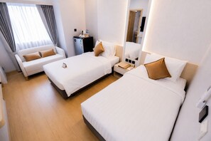A hotel room with two beds, a sofa, a desk with a computer, and a mirror. - 42C Lite Hotel (Mueang Nakhon Sawan)