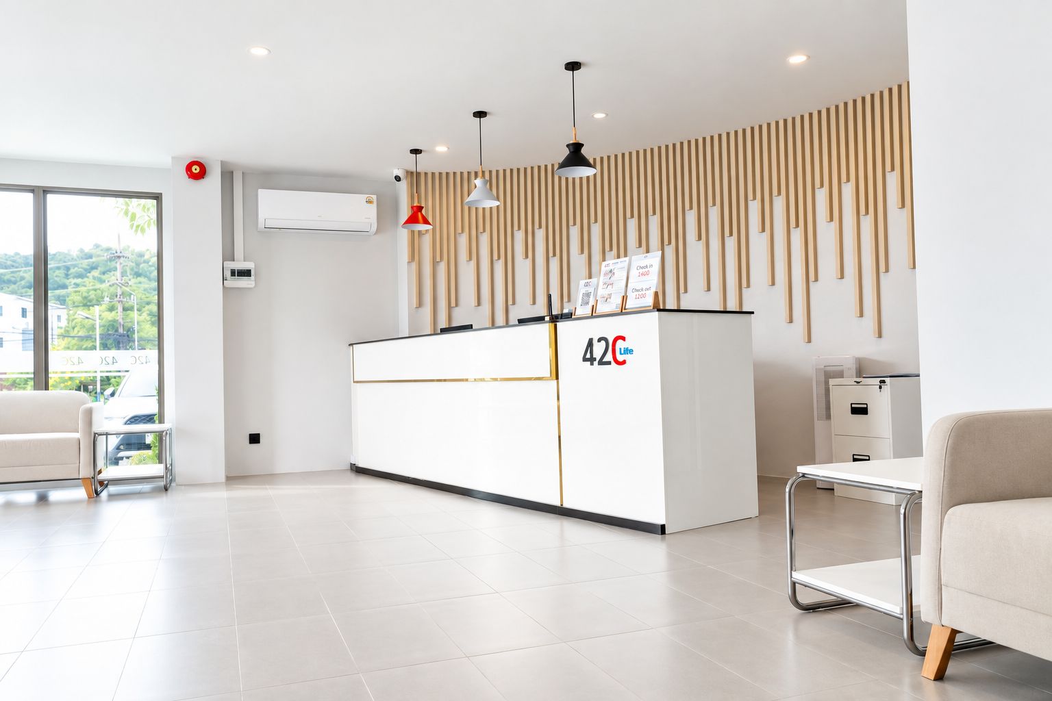 Una moderna reception con un display digitale, un banco accettazione e vista sull'esterno.