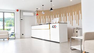 Una moderna reception con un display digitale, un banco accettazione e vista sull'esterno.