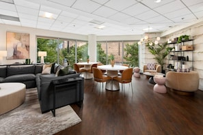 A spacious living area with a large sofa, a dining table with chairs, and a bookshelf. - Blueground | Fulton River District, gym, nr Park (Chicago)