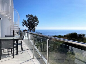A balcony with a glass railing overlooking a coastal view. - Penthouse in Nerja With Sea Views & Pool (Nerja)