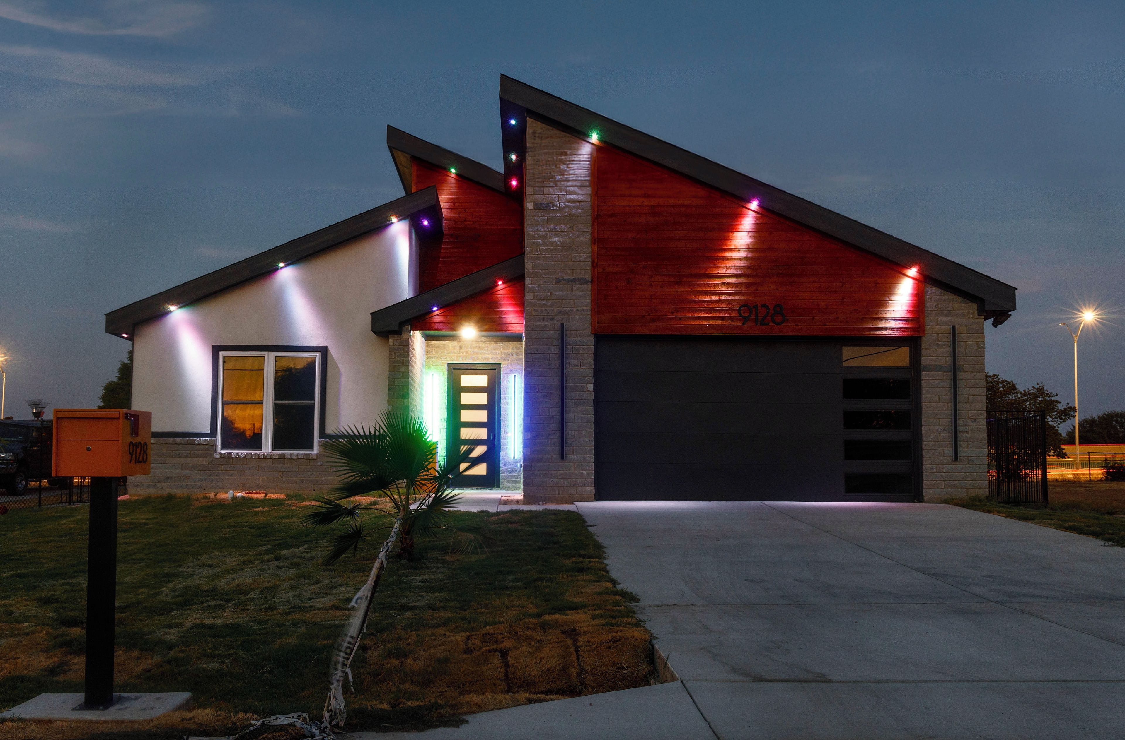 Une maison moderne à deux étages, dotée d’un garage, d’une pelouse bien entretenue et d’une boîte aux lettres.