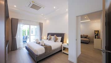 A modern bedroom with a large bed, a bedside table, and a view of a balcony.