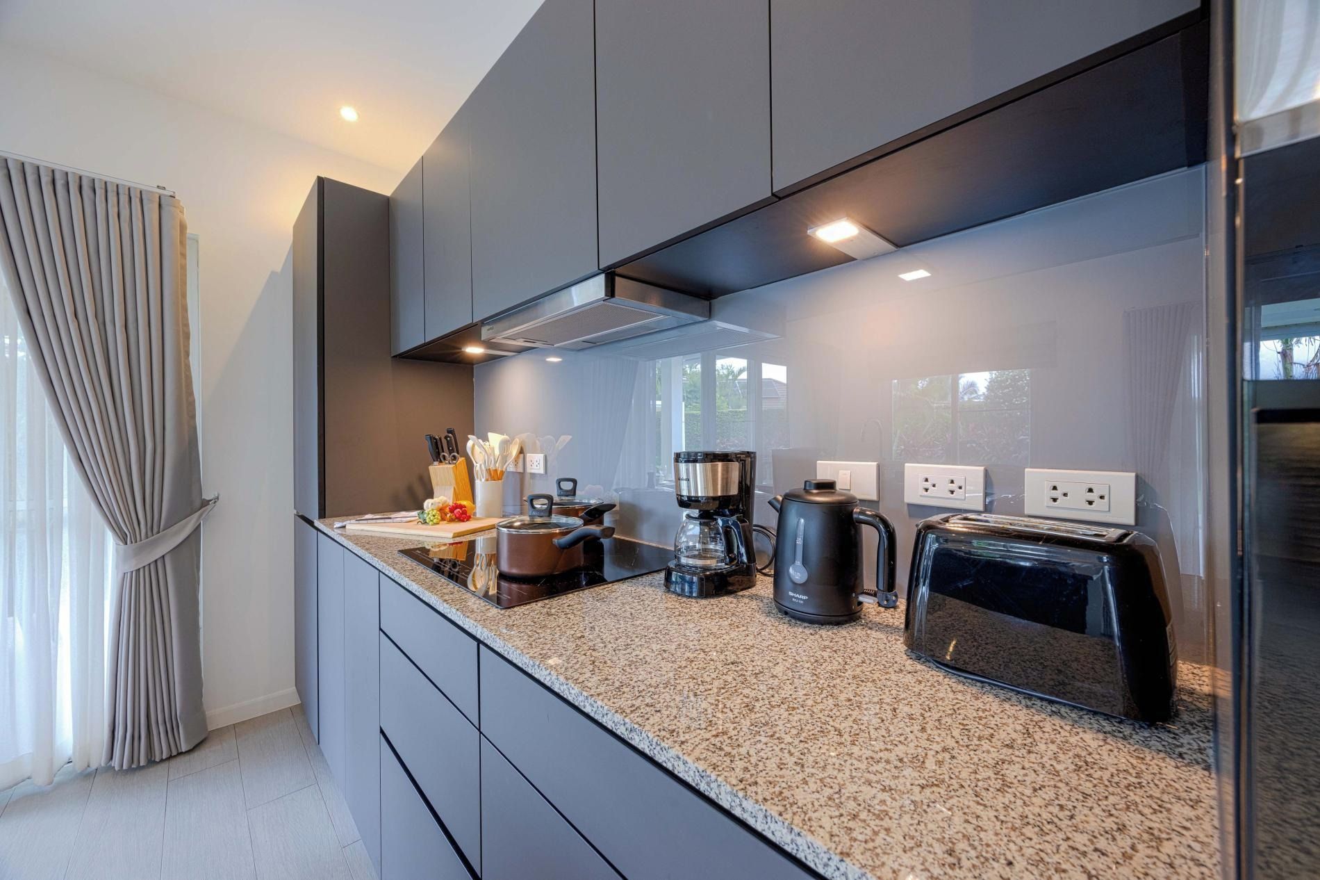 Una cocina moderna con encimeras de granito, electrodomésticos de acero inoxidable y horno empotrado.