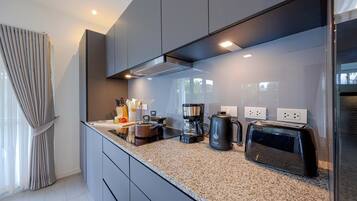 Una cocina moderna con encimeras de granito, electrodomésticos de acero inoxidable y horno empotrado.