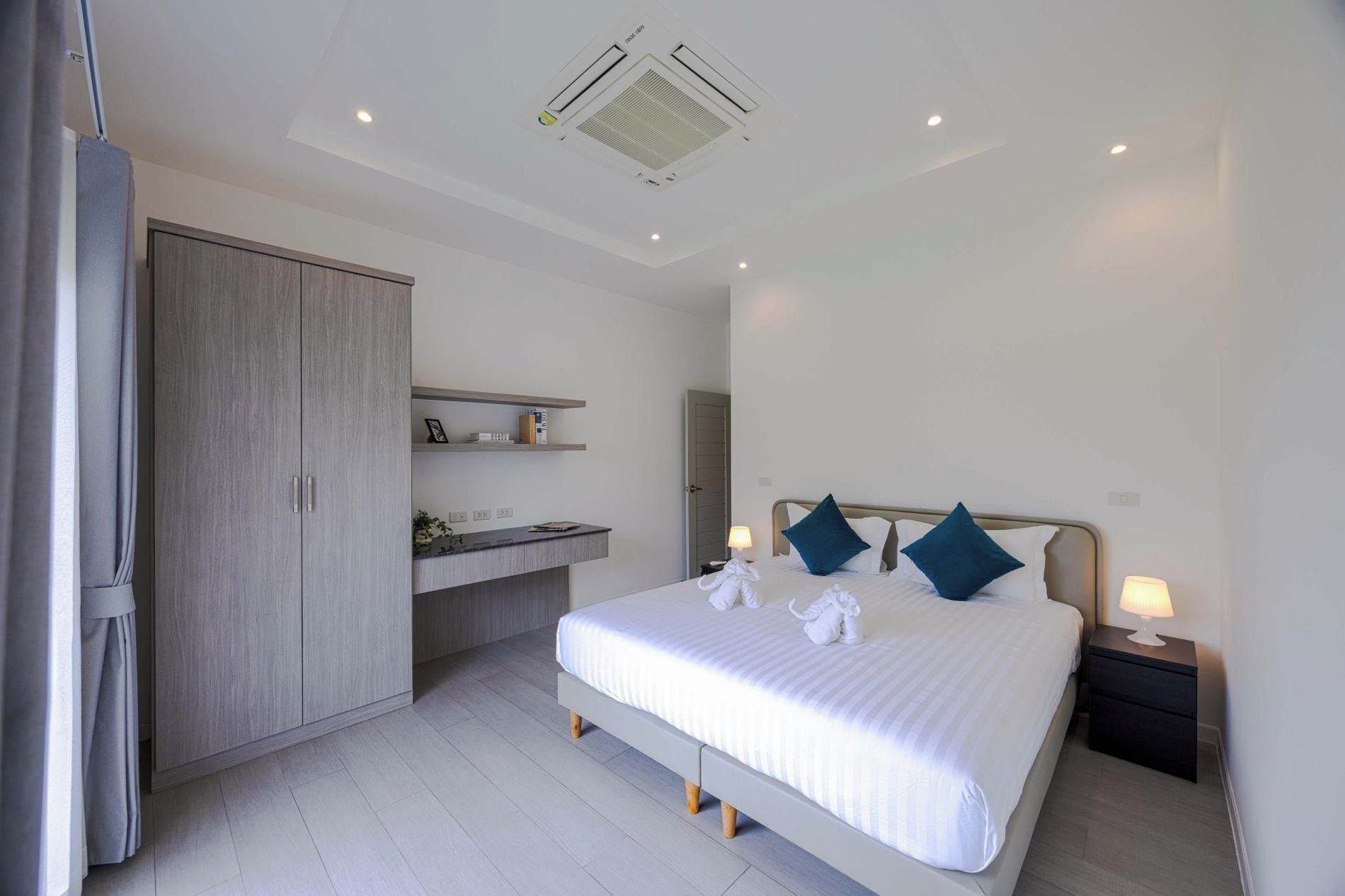 Een hotelkamer met een bed, nachtkastjes, een kledingkast en een plafond met een airconditioning.
