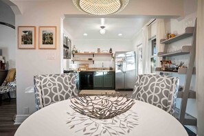 A modern kitchen with built-in appliances, a dining area with patterned chairs, and a chandelier. - Arcadia Retreat | Office, Fast WiFi, Fire Pit (Phoenix)