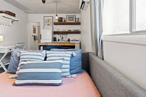 A cozy bedroom with a bed, pillows, a desk, and a window. - Arcadia Studio | Private Entry, Desk + Fast WiFi (Phoenix)