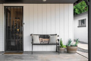 A bench with cushions and potted plants in front of a white door with a metal gate. - Arcadia Studio | Private Entry, Desk + Fast WiFi (Phoenix)