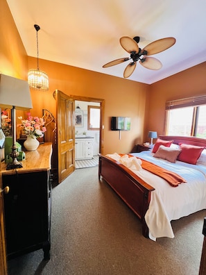 A bedroom with a bed, a ceiling fan, a television, and a wooden dresser. - Vineyard Charm House | McLaren Vale Retreat (Blewitt Springs)