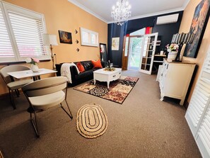 Un salon comprenant un canapé, une table basse et un coin repas avec des chaises.
