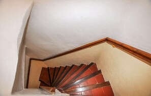 A wooden staircase with a white ceiling and a wooden trim at the top. - Cozy home in Feuilla with WiFi (Feuilla)
