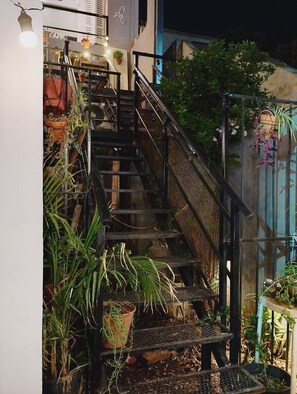 A staircase with metal railings, surrounded by potted plants and hanging baskets. - La calidez de un hogar con excelente ubicación Beccar, san Isidro (Beccar)