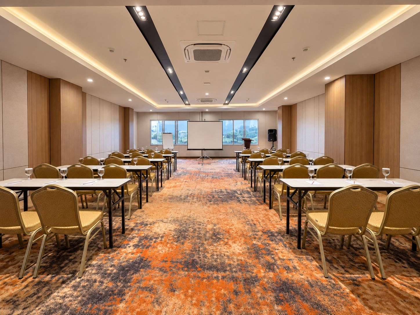 Una sala conferenze con tavoli e sedie, un pavimento rivestito di moquette e uno schermo per proiezioni.