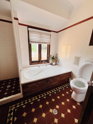 A bathroom with a bathtub, toilet, and a window with blinds. - 5-bedroom vineyard cottage for groups McLaren Vale (Blewitt Springs)
