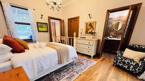 Une chambre à coucher avec un grand lit, une commode, une chaise et un miroir.