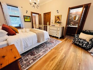 A bedroom with a large bed, a dresser, a chair, and a mirror. - 5-bedroom vineyard cottage for groups McLaren Vale (Blewitt Springs)